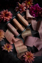 flatlay display with custom silk ribbon and dahlia flowers in pink and yellow color tones