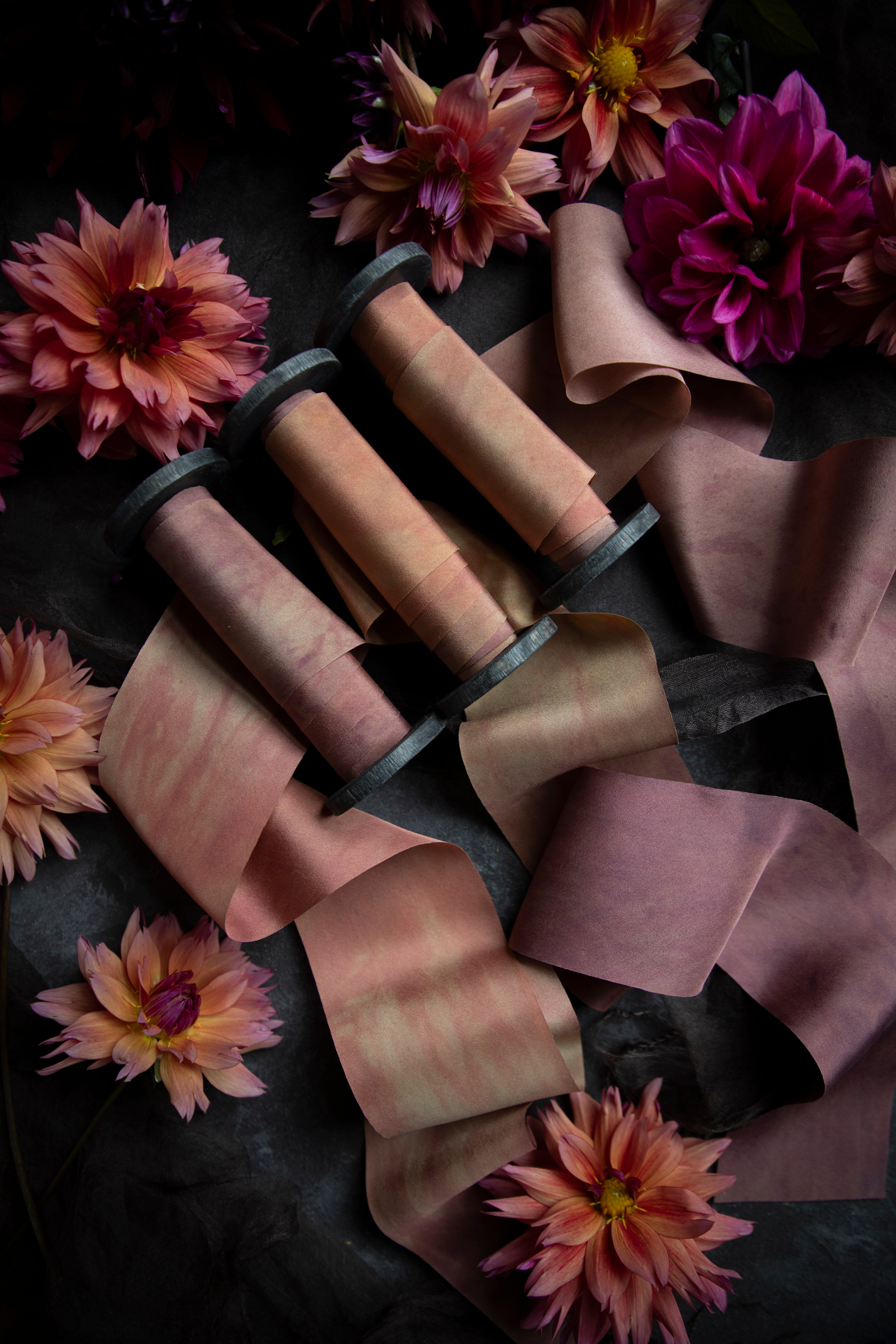 flatlay display with custom silk ribbon and dahlia flowers in pink and yellow color tones