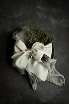 Eco-friendly gray cotton napkins for elegant wedding decor. French gray napkins with champagne ribbon bow.