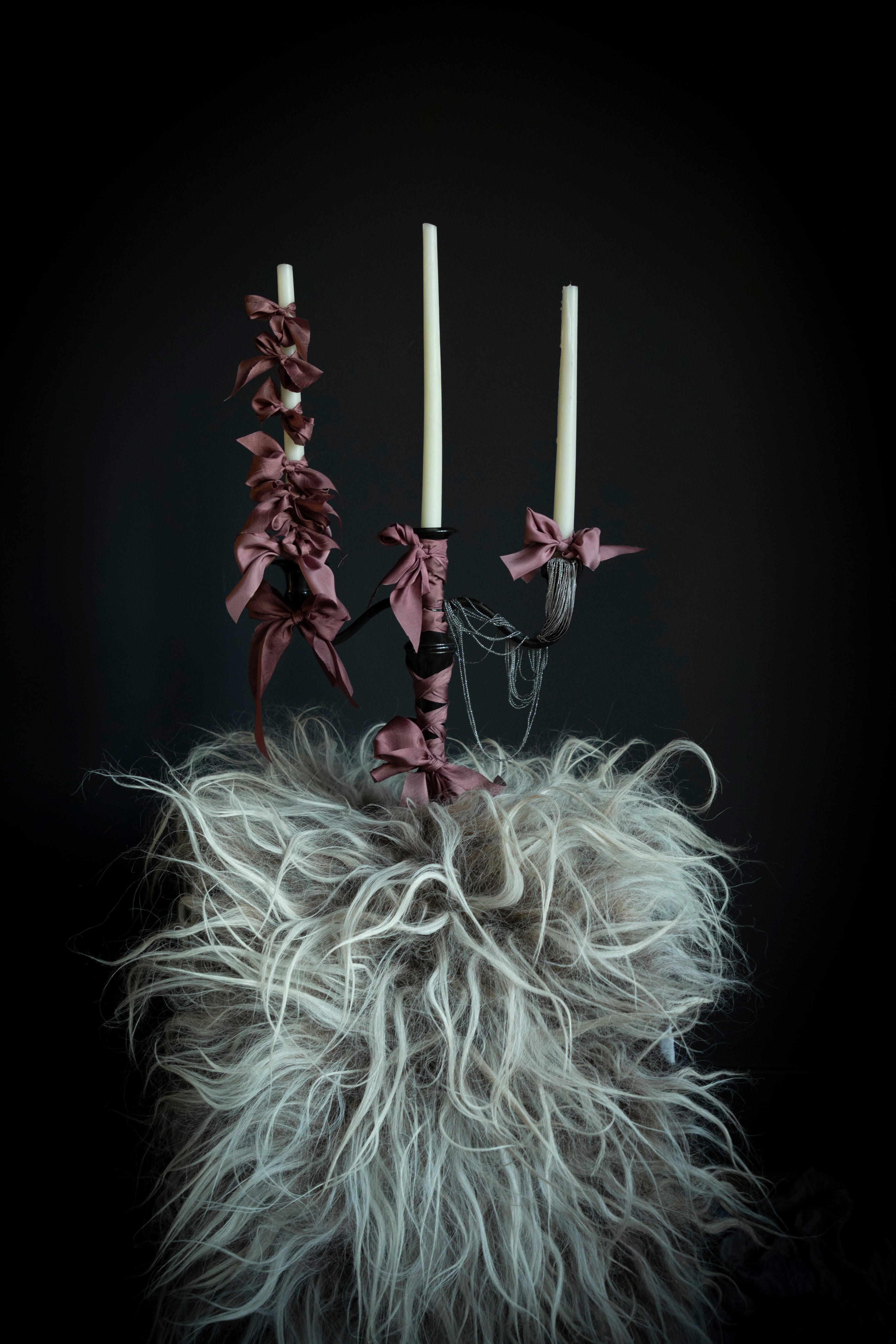 candles with silk ribbon bow. a moody room with viking style wedding inspiration