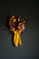 vibrant dried flower wreath with yellow silk ribbon bow