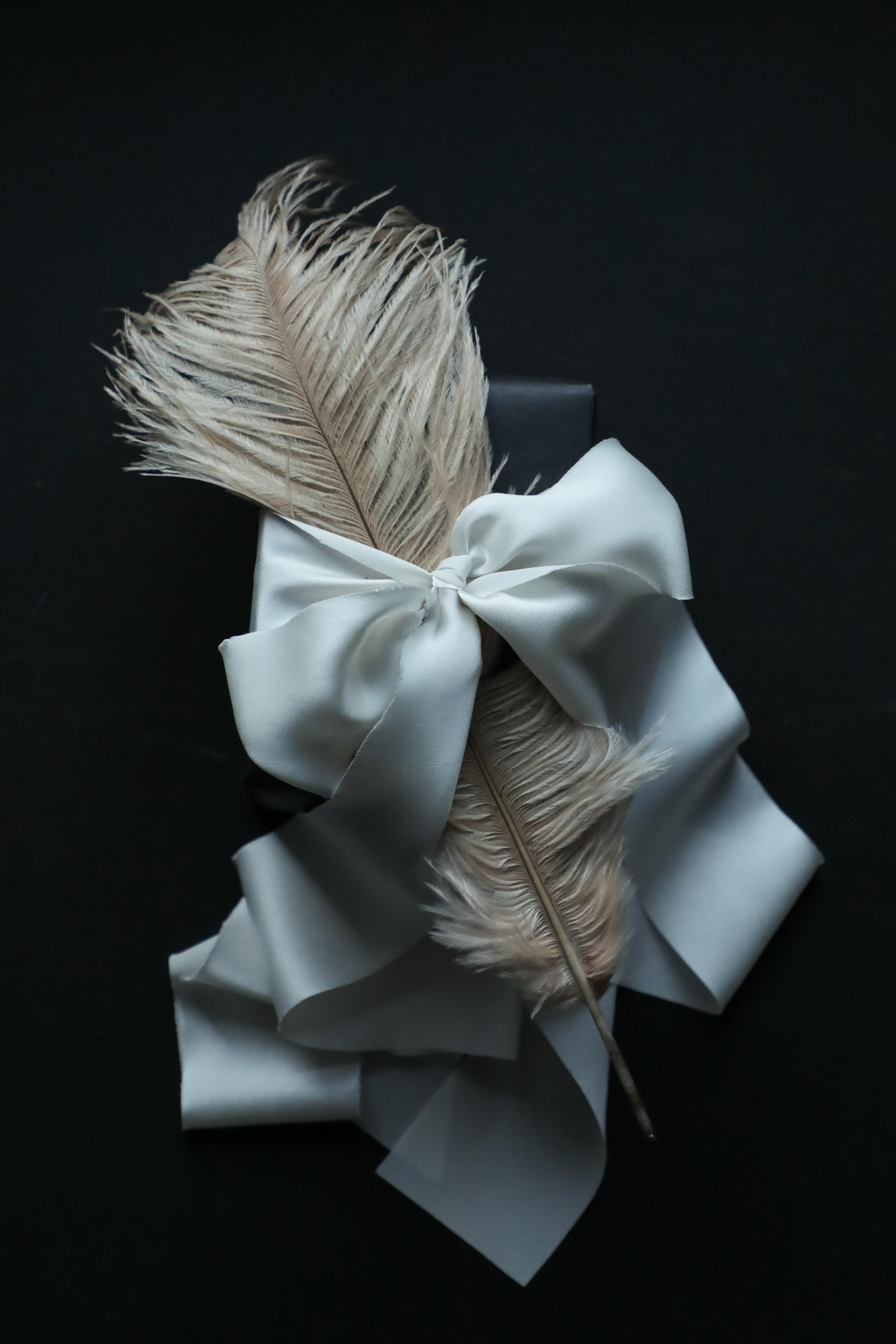 Antique White satin silk ribbon with a feather. Gift wrapping inspiration